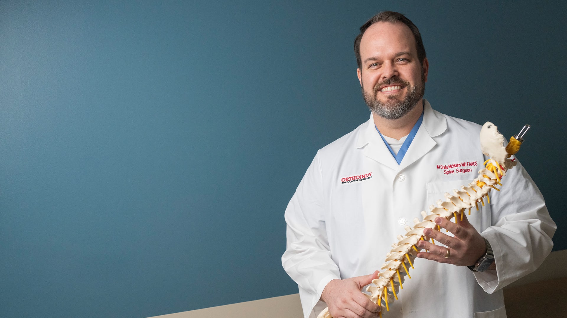 Dr. Craig McMains holding a spine model